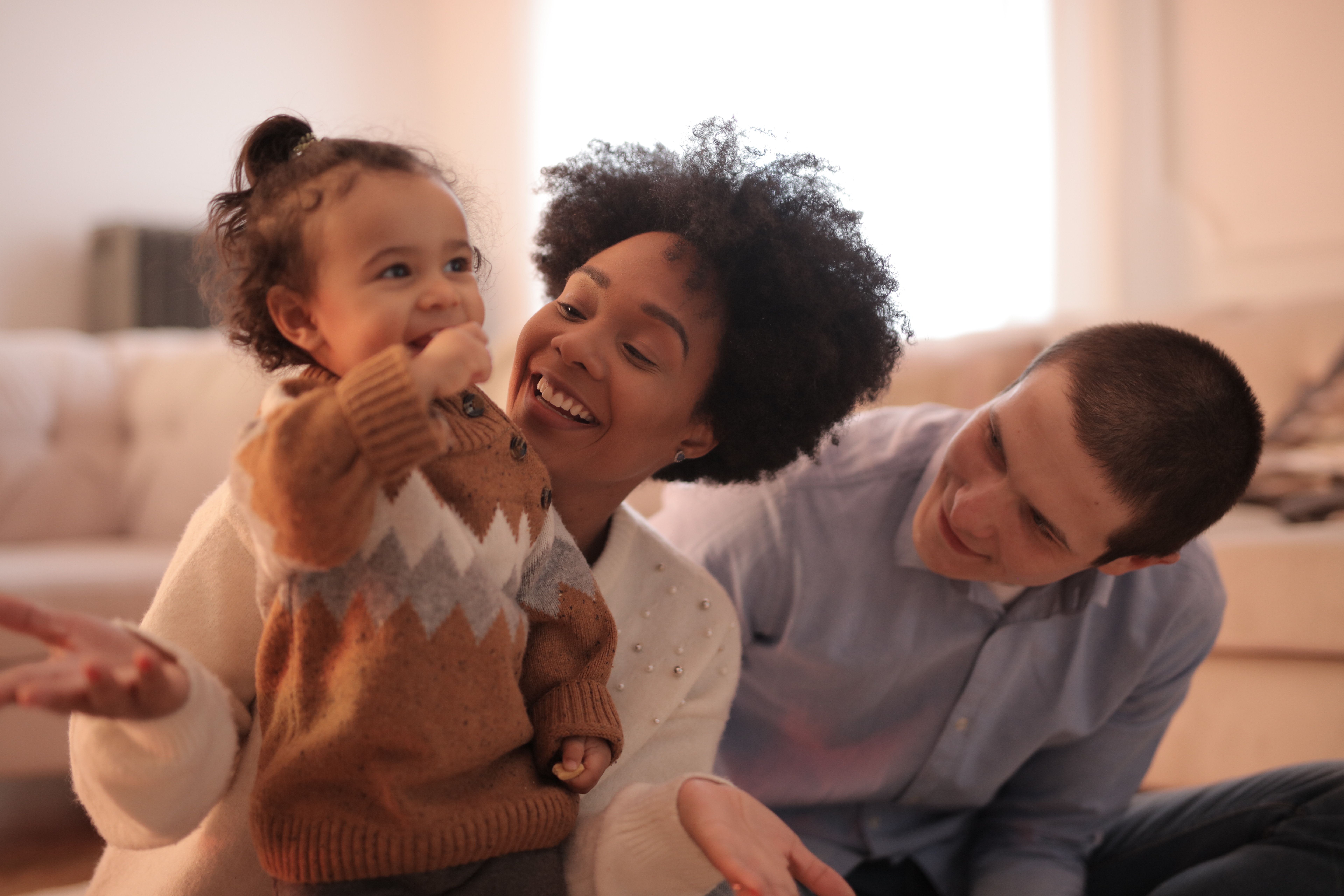 Family with mom, dad and toddler laughing