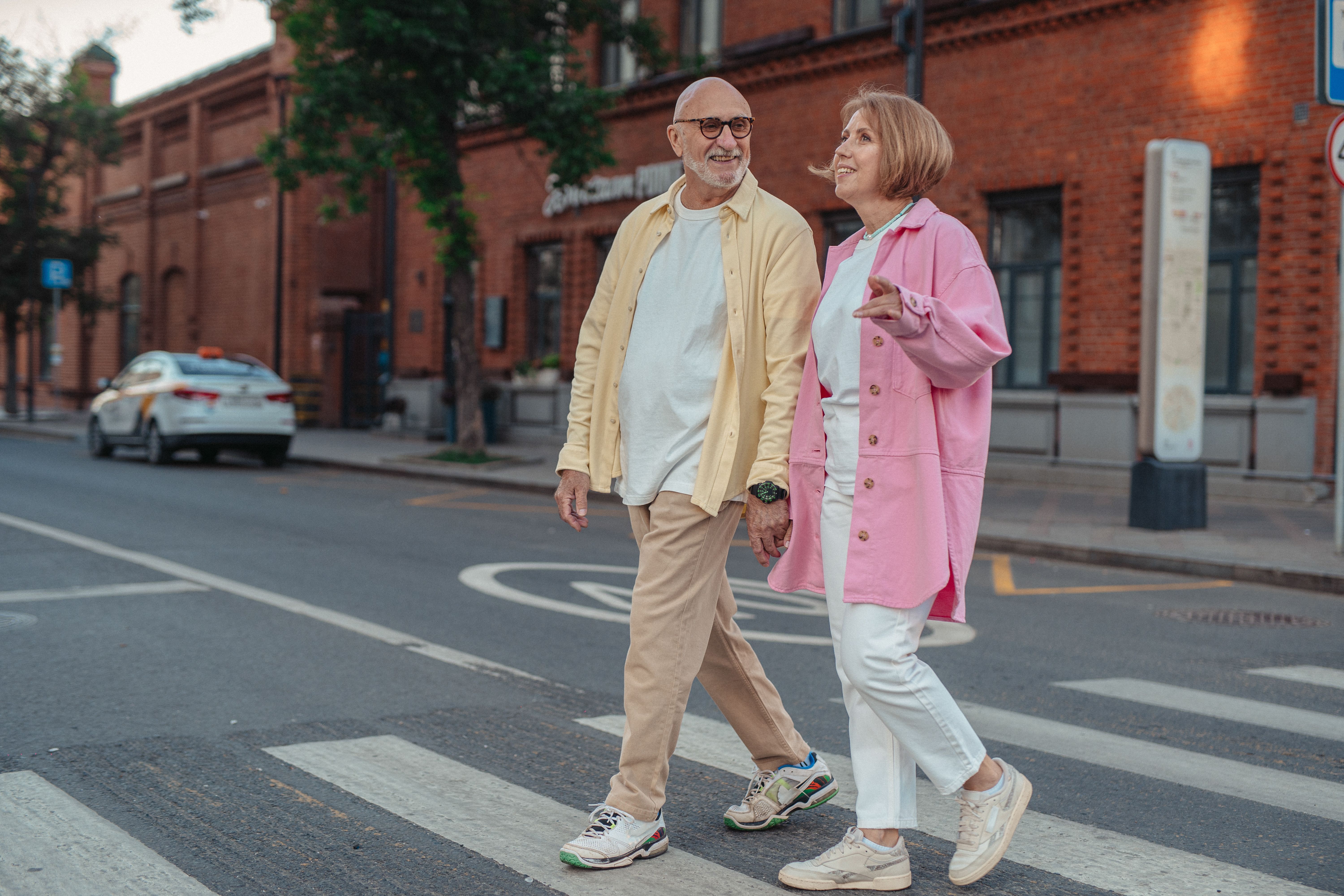 Older couple smiling crossing street